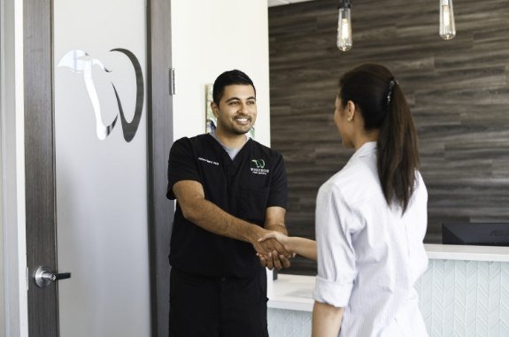 Dentist shaking hands with a patient in Clute dental office