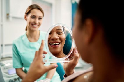 Patient smiling at reflection in treatment chair