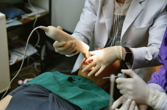 Dentist taking digital dental impressions of a patient's mouth