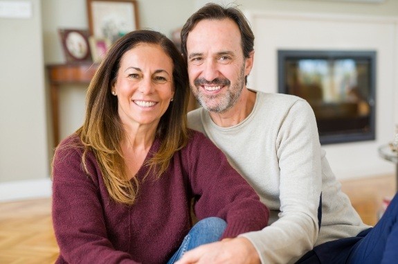 Man and woman smiling while sitting in their living room