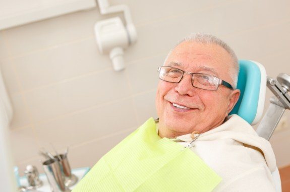 Smiling senior man leaning back in dental chair