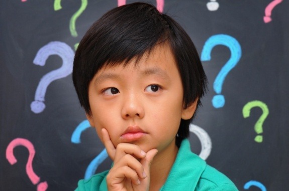 Boy looking confused with question marks in background