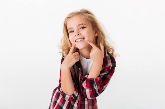 Girl pointing to her smile