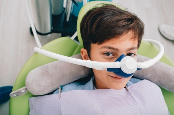 Young boy wearing nitrous oxide sedation mask in dental chair