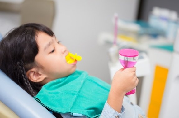 Young girl receiving silver diamine fluoride treatment in dental office
