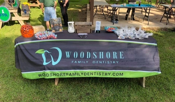 Table with Woodshore Family Dentistry cover on grass