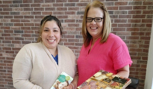 Two smiling women with charcuterie package