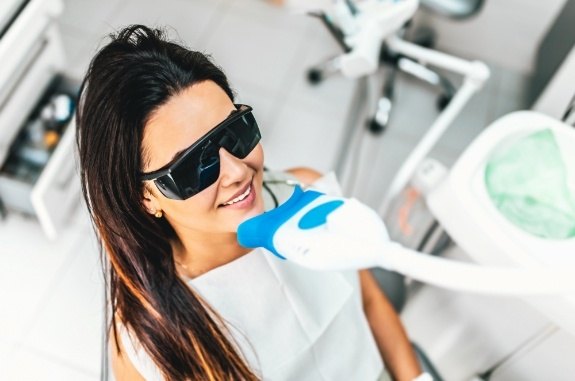 Woman receiving professional teeth whitening from cosmetic dentist