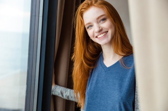 Smiling young woman with dark blue shirt and red hair