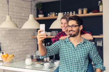 Man and woman taking selfie in their kitchen