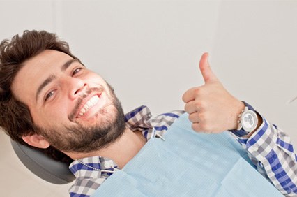 Bearded male dental patient giving a thumbs up