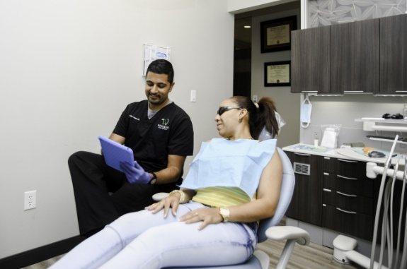 Dentist explaining to a patient what a dental deep cleaning in Clute is