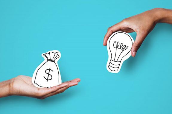 One hand holding a bag of money graphic while the other holds a lightbulb graphic