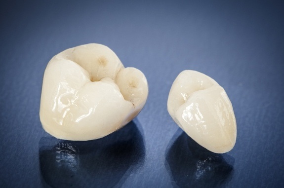 Two dental crowns against dark blue background