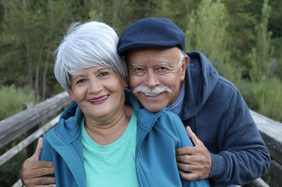 Senior man and woman holding each other outdoors