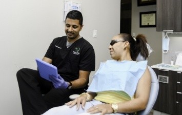 Dentist showing a tablet to a dental patient