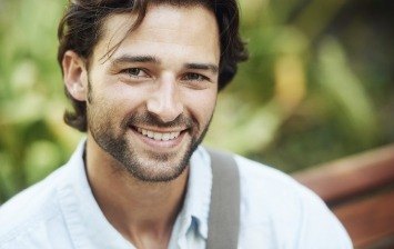 Man with short beard smiling outdoors
