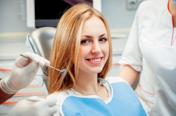 Woman in dental chair smiling before gingivectomy in Clute