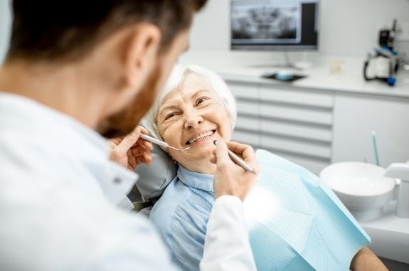 Elderly woman smiling at her dentist