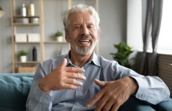 Man in light blue collared shirt sitting on couch