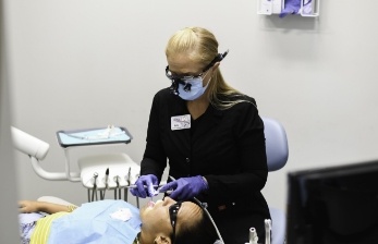 Dental team member examining a patient's mouth