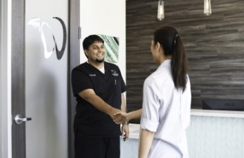 Doctor Desai shaking hands with a dental patient