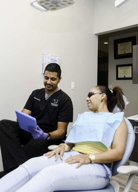 Doctor Pattni showing a tablet to a dental patient