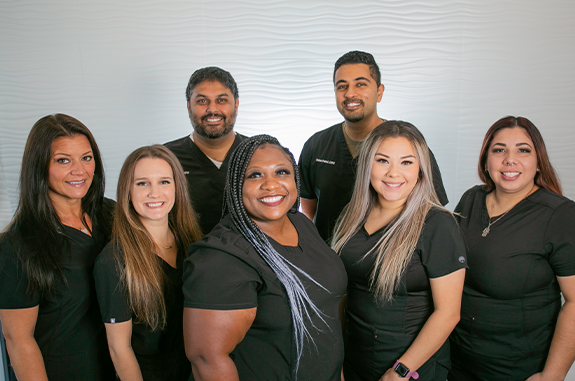 The smiling Clute dentists and team at Woodshore Family Dentistry