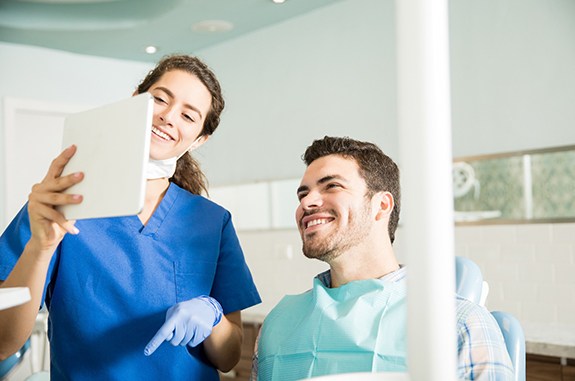 Dentist showing patient image on tablet