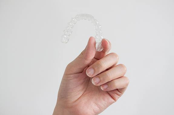 Patient holding up clear aligner