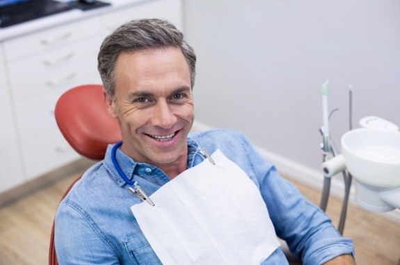 Older man smiling in dental chair