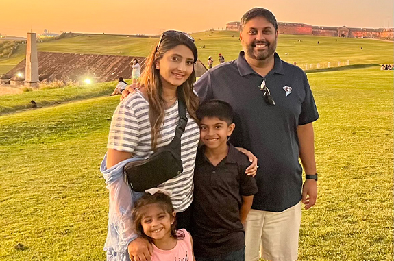 Doctor Desai in a field with his wife and two children