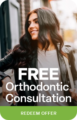 Woman in leather jacket leaning against brick wall