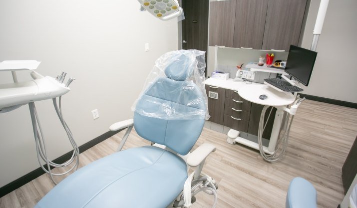 Light blue dental chair with computer in background