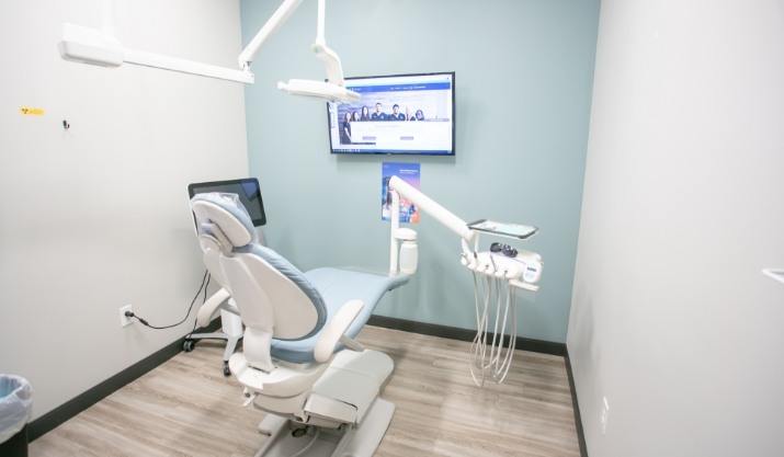 Dental treatment room with T V on wall