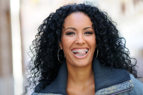 Woman with traditional braces grinning outdoors