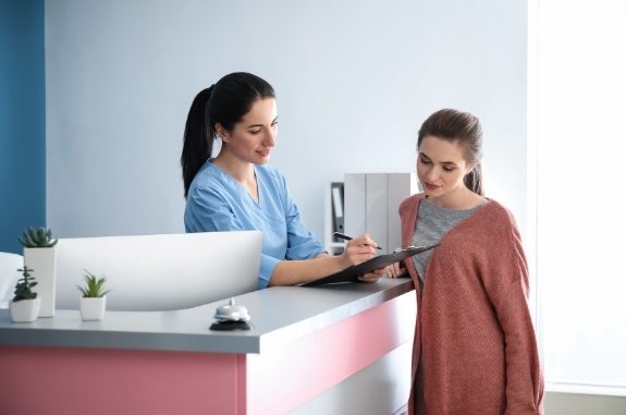 Dental team member showing a clipboard to a patient