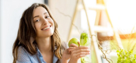 Smiling young woman sitting outdoors with ladder in background