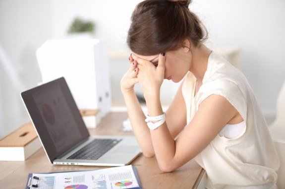 Woman who needs sleep apnea treatment in Clute nearly falling asleep while sitting at desk