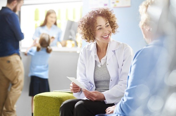 Two women chatting in dental office waiting room